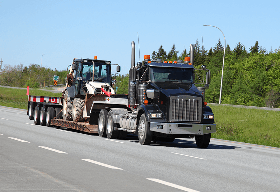 Truck pulling construction equipment